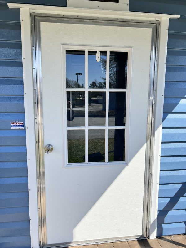 36×72-Single-Door-w-9-Light-600×800 White single door with nine-light window, framed in silver, set against blue siding of a portable building, showcasing customizable storage options.