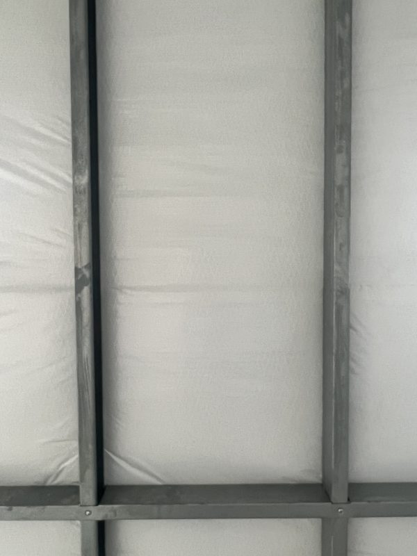 Insulation-600×800 Interior view of insulated portable building showing metal frame and insulation panels, highlighting customizable features for storage solutions by Repo Lot.