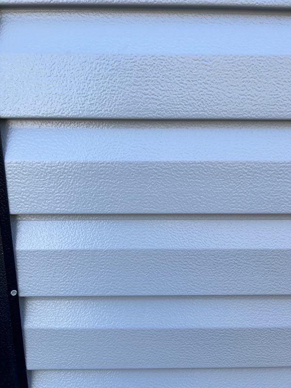 Lap-Aluminum-Siding-600×800 Textured aluminum siding in light gray, showcasing customizable options for portable buildings and sheds by Repo Lot.