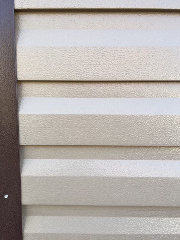 Lap-Steel-Siding-600×800 Textured beige lap steel siding with a dark brown trim, showcasing customizable exterior options for portable buildings and sheds.