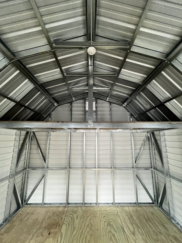 Loft-600×800 Interior view of a customizable portable storage building featuring a metal frame, wooden floor, and peaked roof, showcasing structural design options for potential customers at Repo Lot.