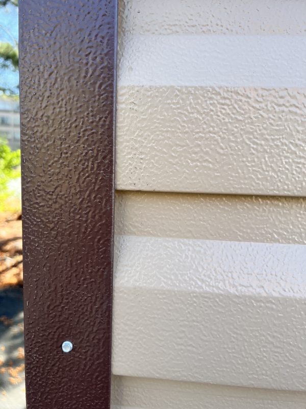 Metal-Trim-600×800 Close-up of metal trim alongside textured beige siding, highlighting customization options for portable buildings and sheds by Repo Lot.