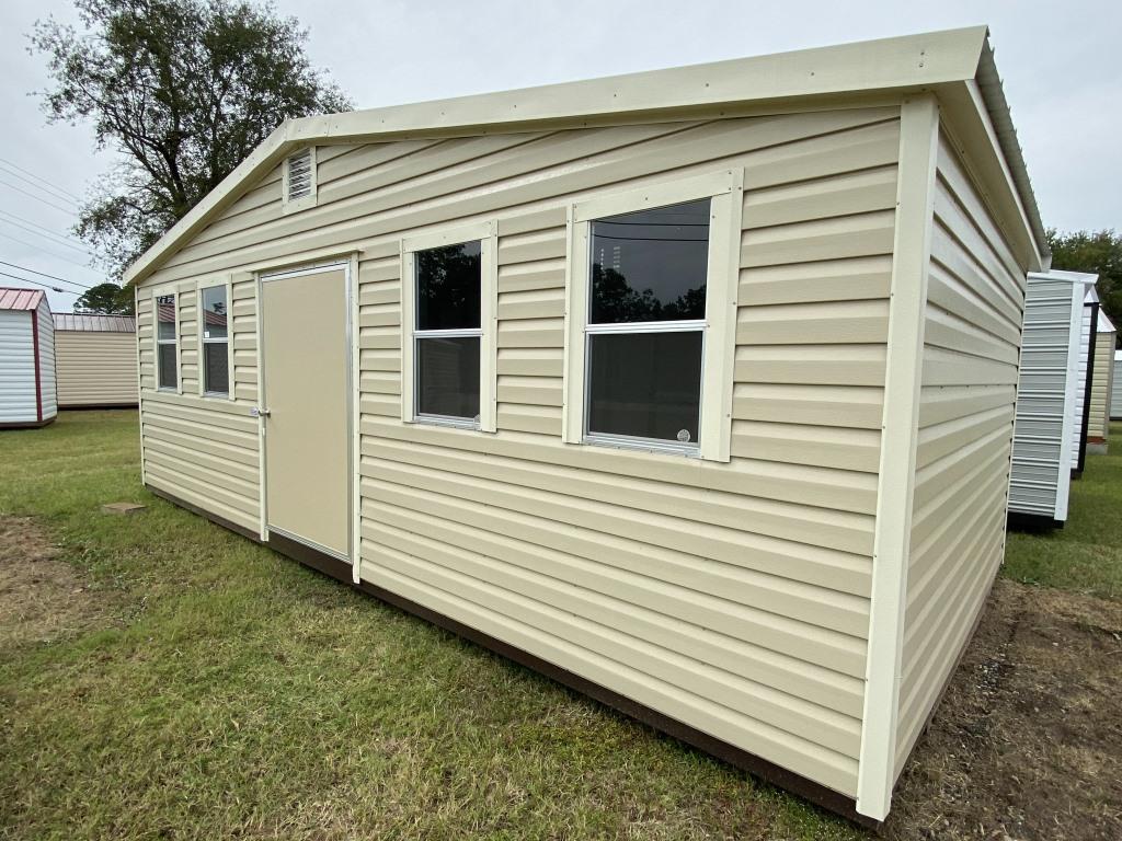 Side-gable portable cabin in Auburn, AL, featuring beige siding, multiple windows, and a door, showcasing versatility for storage, office, or workshop use.