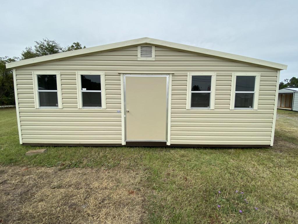 Side gable portable cabin with beige exterior, front door, and windows, set in grassy area, highlighting functional design for storage or workspace.