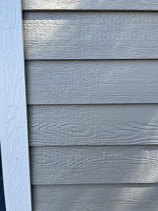 Smart-Lap-Siding-600×800 Gray smart lap siding with textured finish and white trim, showcasing customizable building options for portable storage solutions.