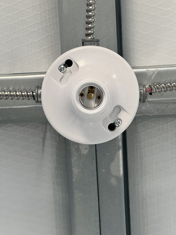Standard-Light-Fixture-600×800 Light fixture with electrical connections, mounted to a ceiling frame, relevant for customizable portable buildings and sheds.