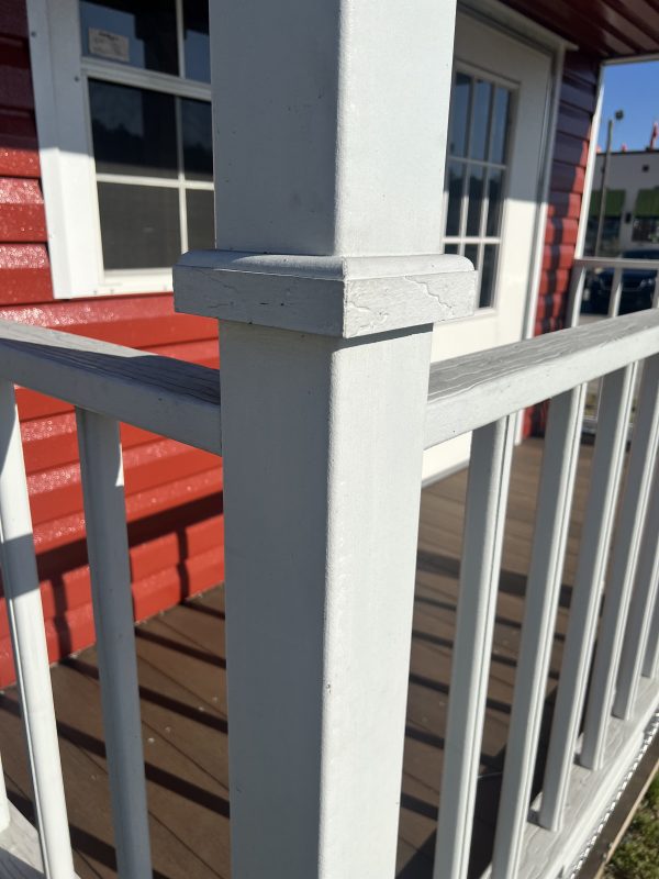 Upgraded-to-White-Painted-Porch-Railings-and-Posts-Floor-Isnt-Painted-600×800 White-painted porch railings and posts with a wooden floor, showcasing customizable design options for portable buildings by Repo Lot.