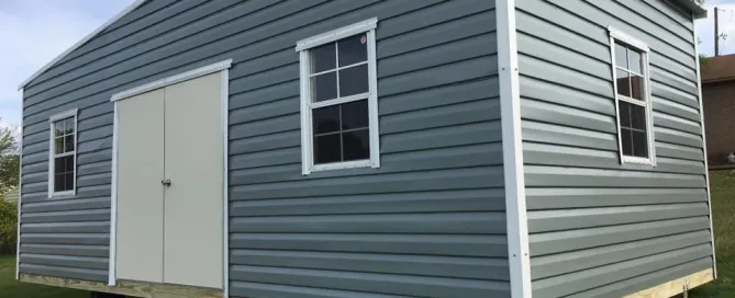 Gray portable storage shed with white trim and a single door, showcasing affordable storage solutions
